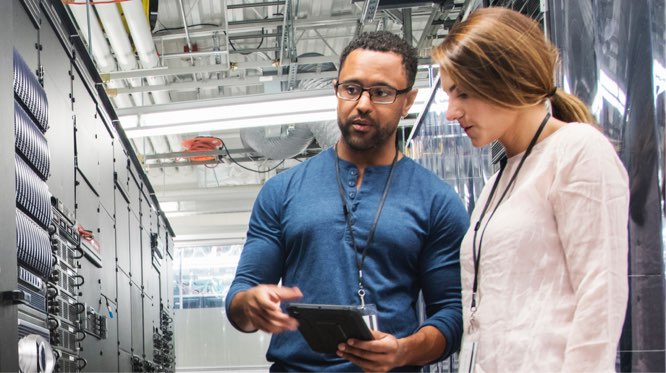 two people talking in a data center, looking at equipment